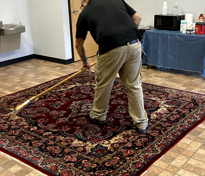 a guy sweeping an area rug