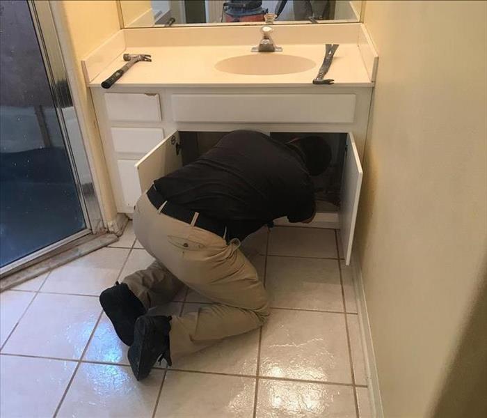 restoration technician searching for a leak in plumbing pipes