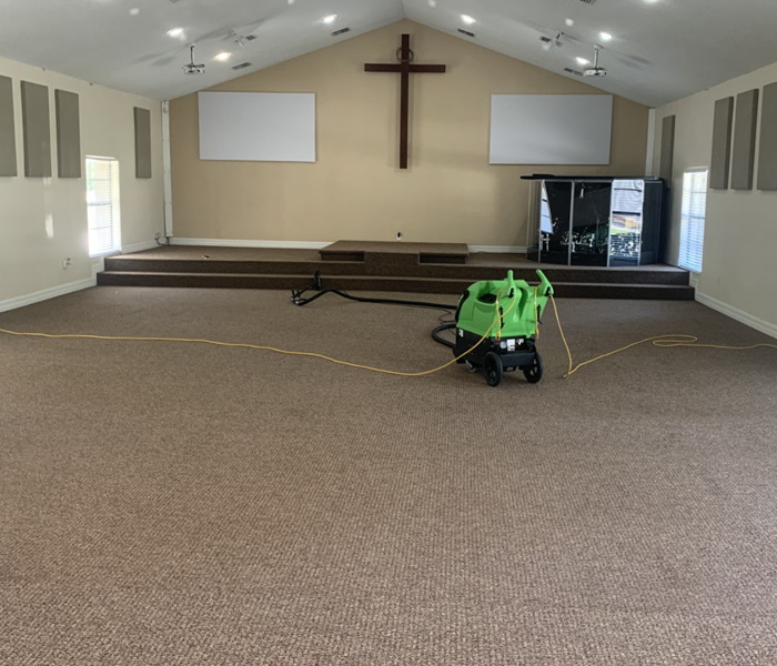 a church interior with green drying equipment on the ground