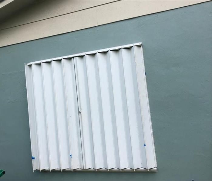 Metal accordion storm shutters closed to protect a home from the oncoming hurricane.